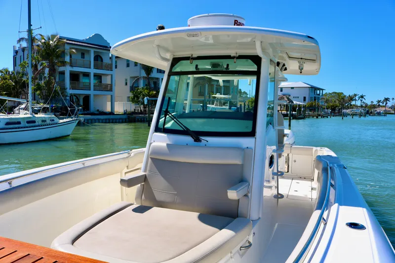 Slide: The Image of 2022 Boston Whaler 330 Outrage boat docked in sunny marina setting. - 21