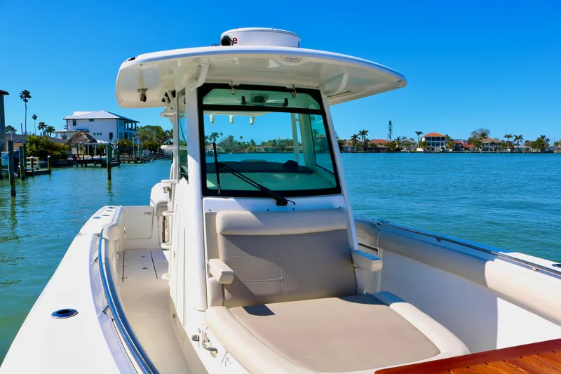 Slide: The Image of 2022 Boston Whaler 330 Outrage boat on calm water, sunny day, coastal background. - 22