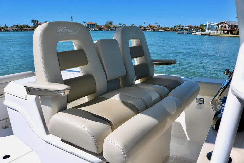 Slide: The Image of 2022 Boston Whaler 330 Outrage boat seating with scenic waterfront view. - 24