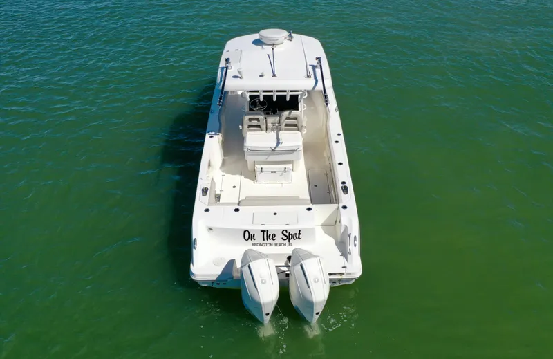 Slide: The Image of 2022 Boston Whaler 330 Outrage boat on water, rear view with dual engines. - 4