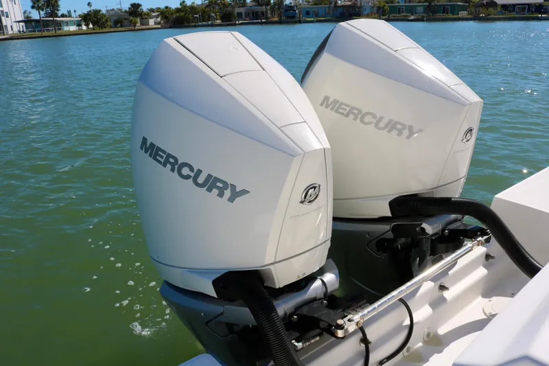 Slide: The Image of Twin Mercury engines on a 2022 Boston Whaler 330 Outrage in a serene water setting. - 40