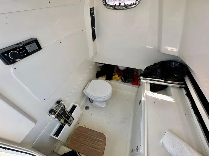 Slide: The Image of Interior of 2022 Boston Whaler 330 Outrage boat, featuring a compact bathroom. - 44