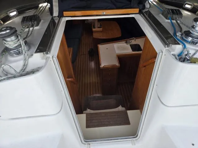 Slide: The Image of Interior view of 2002 Hunter 356 sailboat, featuring wooden cabinetry and compact kitchen area. - 14