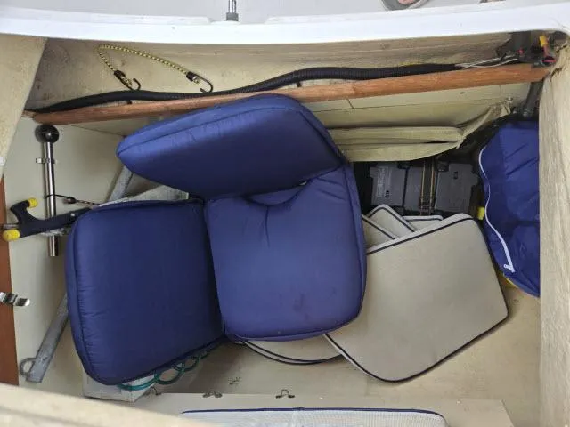 Slide: The Image of 2002 Hunter 356 sailboat interior with blue cushions and storage area. - 18