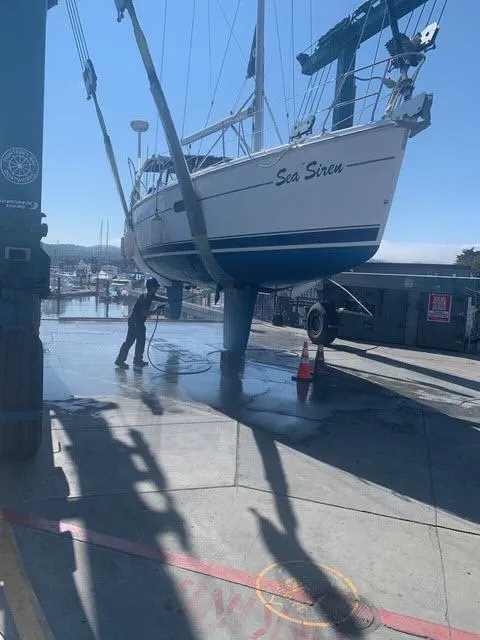 Slide: The Image of Hunter 356 sailboat named "Sea Siren" being lifted at a marina, 2002 model. - 24