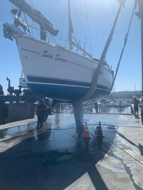 Slide: The Image of Hunter 356 sailboat named "Sea Siren" being lifted at a marina, 2002 model. - 25