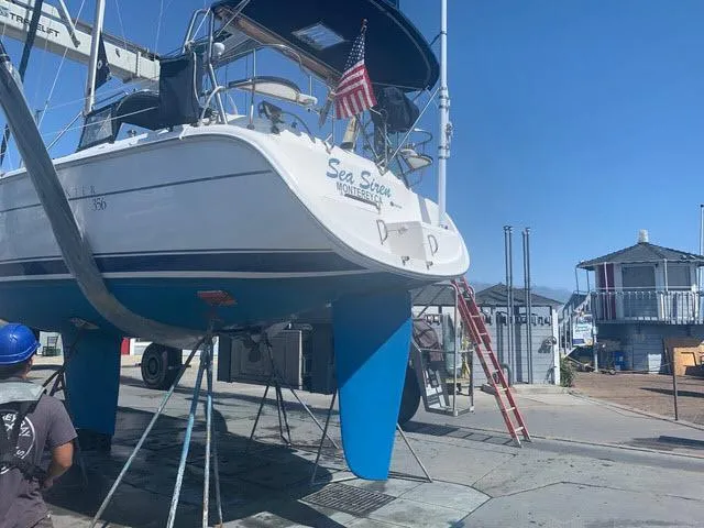 Slide: The Image of Hunter 356 sailboat from 2002 on dry dock, with American flag and maintenance equipment. - 26