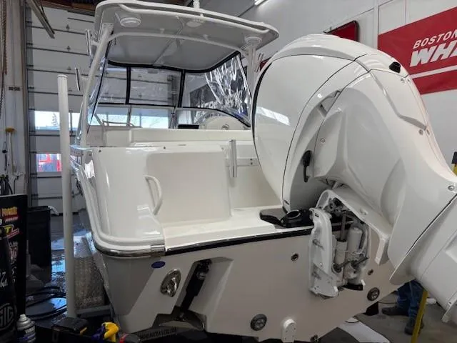 Slide: The Image of 2023 Edgewater 248 CX boat in a garage, featuring a powerful outboard motor. - 3