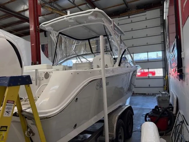 Slide: The Image of 2023 Edgewater 248 CX boat in a garage, on a trailer, with protective cover. - 4