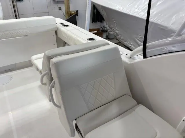Slide: The Image of 2023 Edgewater 248 CX boat interior with white cushioned seating. - 7