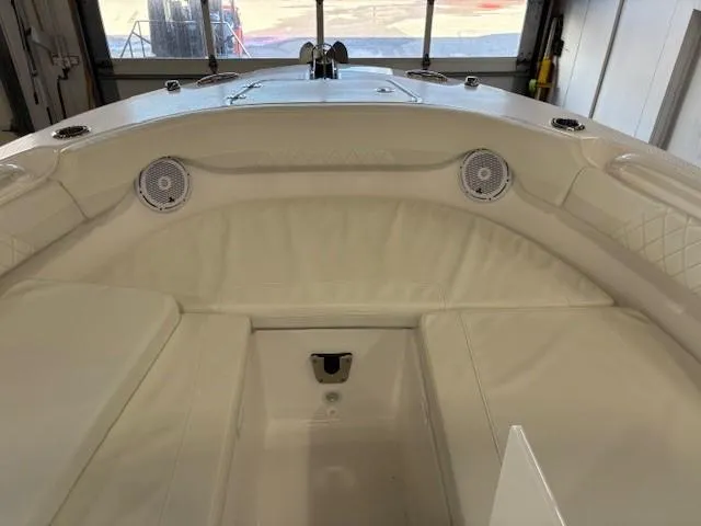 Slide: The Image of 2023 Edgewater 248 CX boat interior with cushioned seating and built-in speakers. - 8
