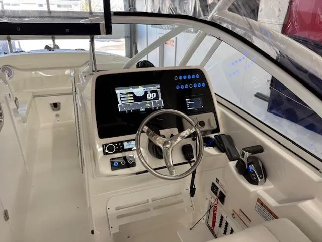 Slide: The Image of 2023 Edgewater 248 CX boat cockpit with modern controls and steering wheel. - 9