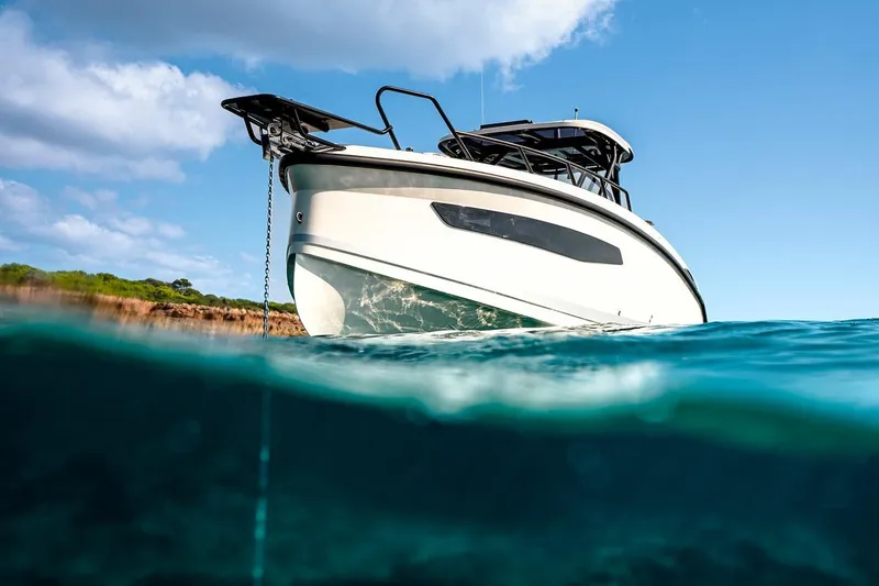 Slide: The Image of 2025 Navan S30 boat anchored in clear blue water under a sunny sky. - 16
