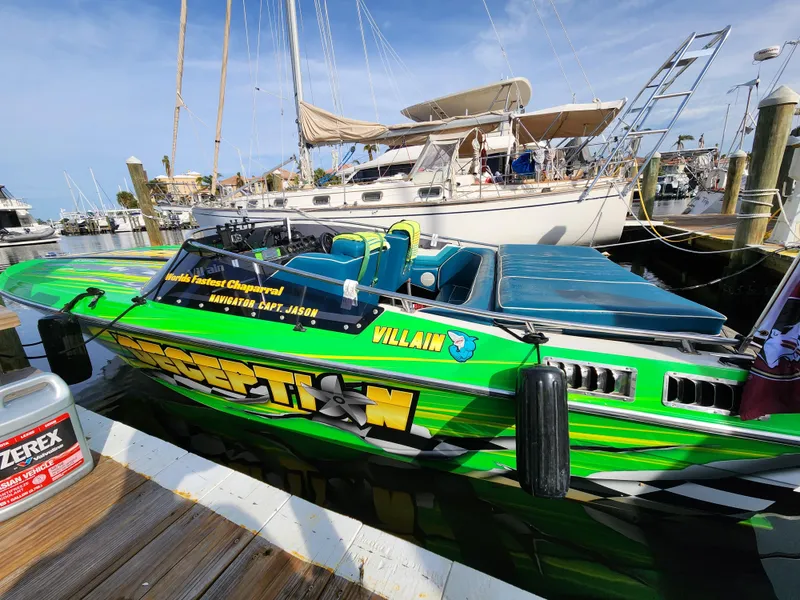 Slide: The Image of 1987 Chaparral Villan II speedboat docked, vibrant green design, marina background. - 1