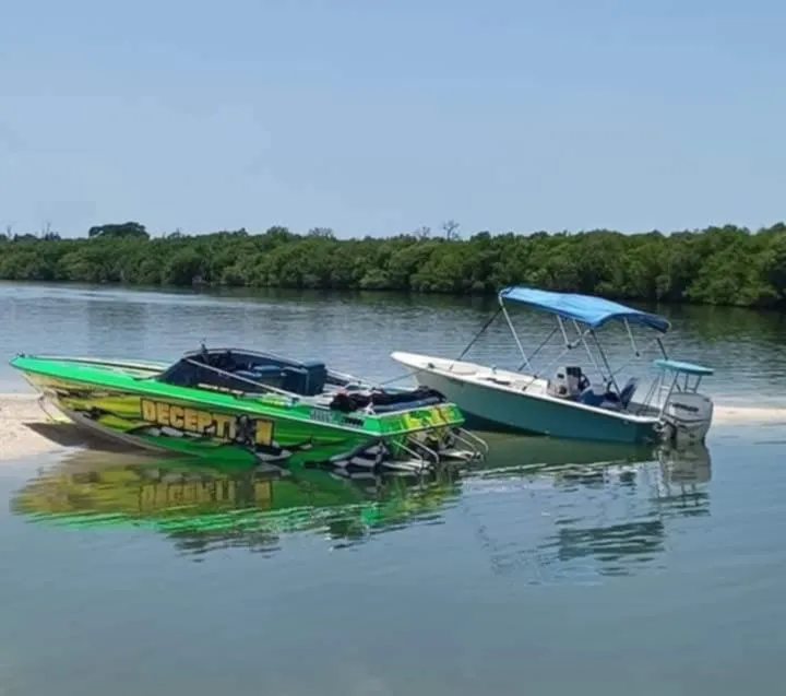 Slide: The Image of Two boats beached on a sandy shore, including a 1987 Chaparral Villan II. - 11