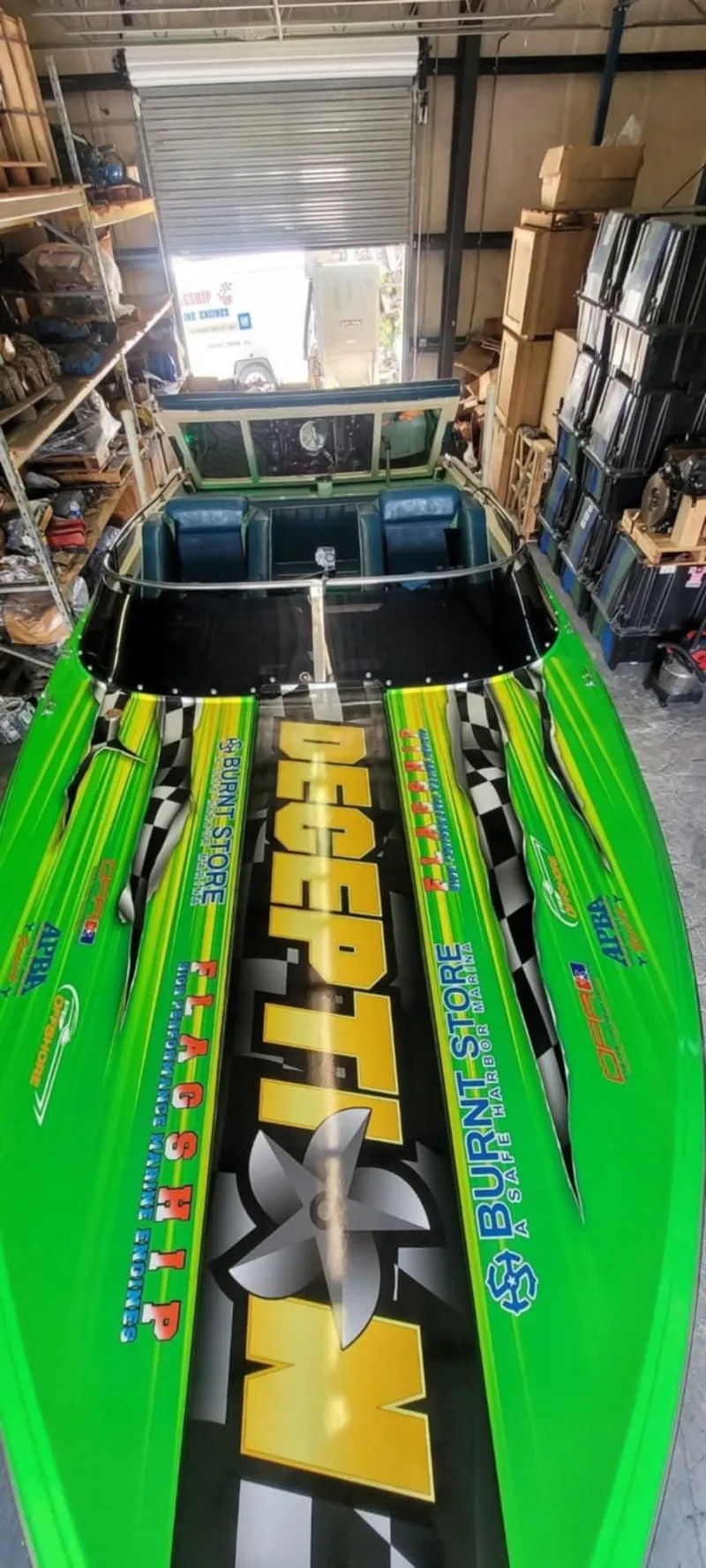 Slide: The Image of 1987 Chaparral Villan II speedboat with vibrant green graphics in a storage facility. - 13