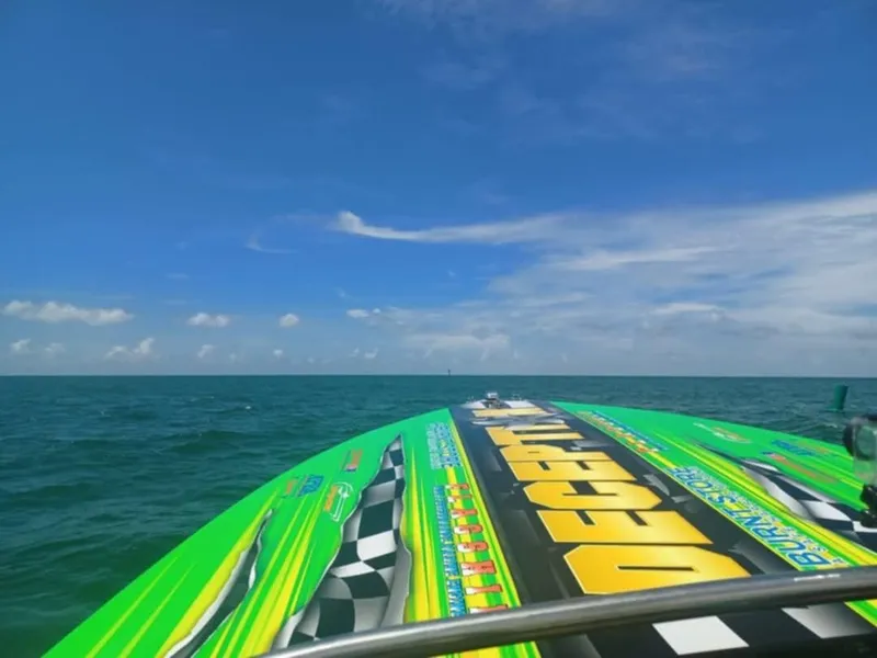 Slide: The Image of 1987 Chaparral Villan II speedboat on open sea with vibrant graphics under clear blue sky. - 7