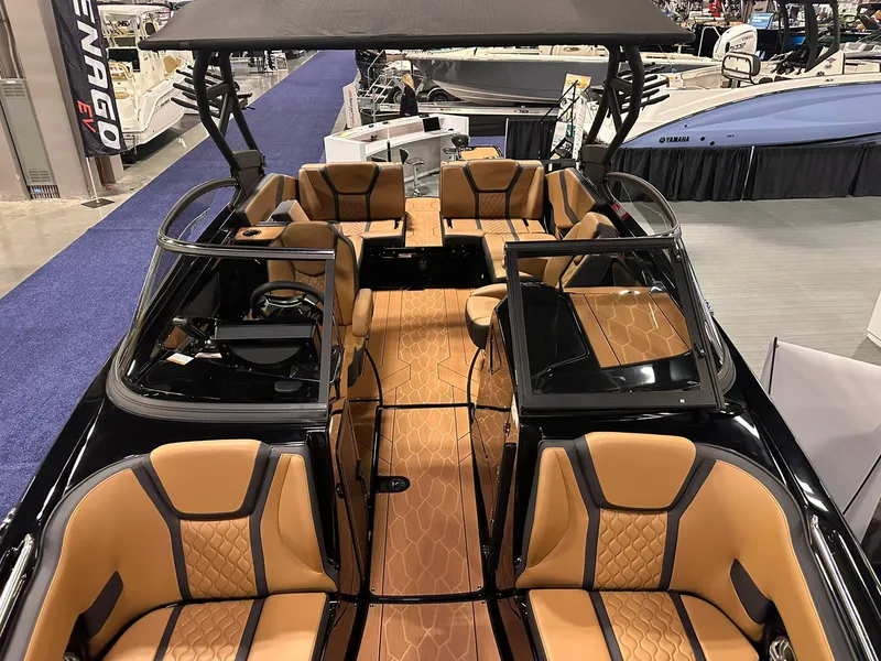 Slide: The Image of 2025 Yamaha Boats 255XD interior with luxurious tan seating and sleek design at a boat show. - 24