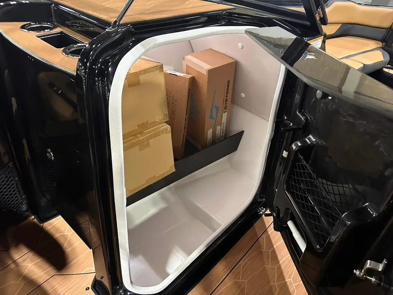 Slide: The Image of 2025 Yamaha Boats 255XD storage compartment with cardboard boxes inside. - 30