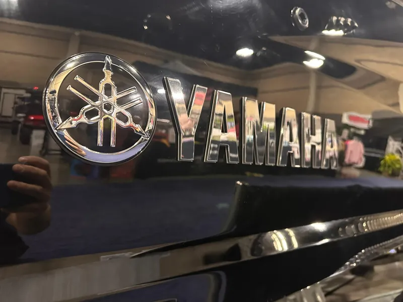 Slide: The Image of 2025 Yamaha Boats 255XD logo on sleek black surface at a boat show. - 4