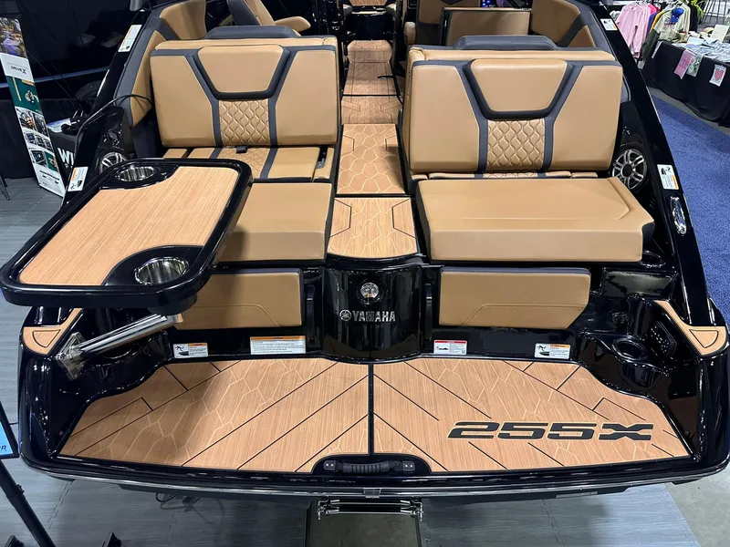Slide: The Image of 2025 Yamaha Boats 255XD interior with tan seating and wood-style flooring. - 6