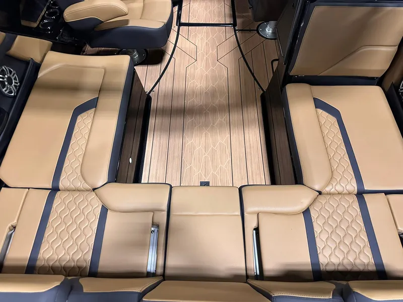 Slide: The Image of 2025 Yamaha Boats 255XD interior with tan leather seating and wood-patterned flooring. - 8