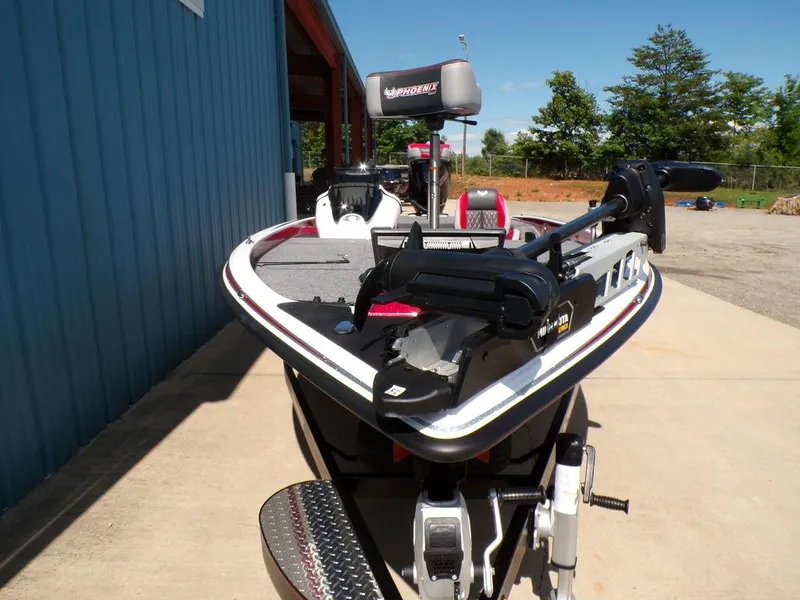 Slide: The Image of Control panel of 2025 Phoenix 920 Elite boat with red metallic finish and keychain. - 21