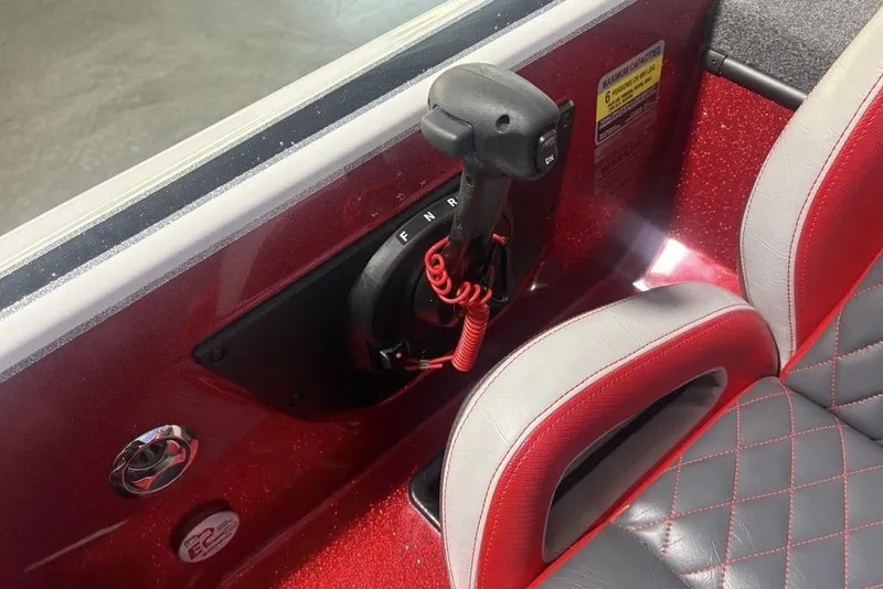 Slide: The Image of Interior of 2025 Phoenix 920 Elite boat with control lever and red-gray seating. - 25