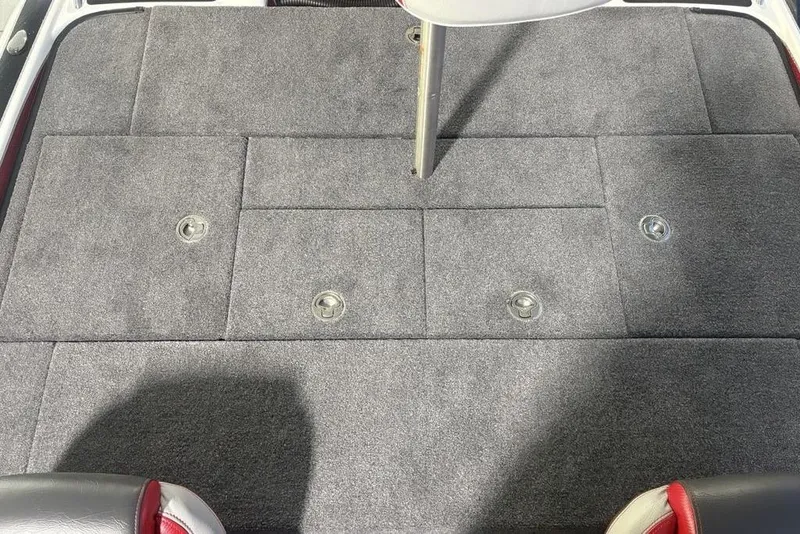 Slide: The Image of 2025 Phoenix 920 Elite boat deck with gray carpet and storage compartments. - 26