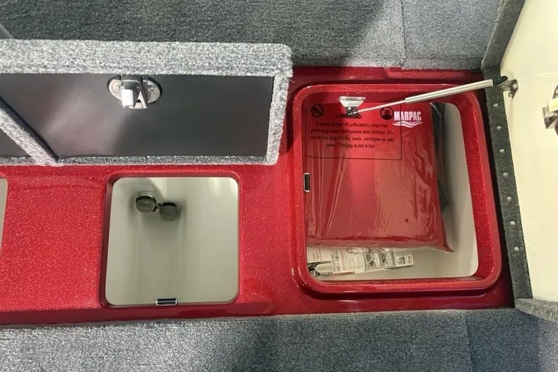 Slide: The Image of Storage compartments in a 2025 Phoenix 920 Elite boat, featuring red and gray interiors. - 28