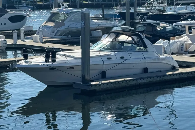 Slide: The Image of 1998 Sea Ray 400 Express Cruiser docked at a marina, reflecting on calm water. - 1