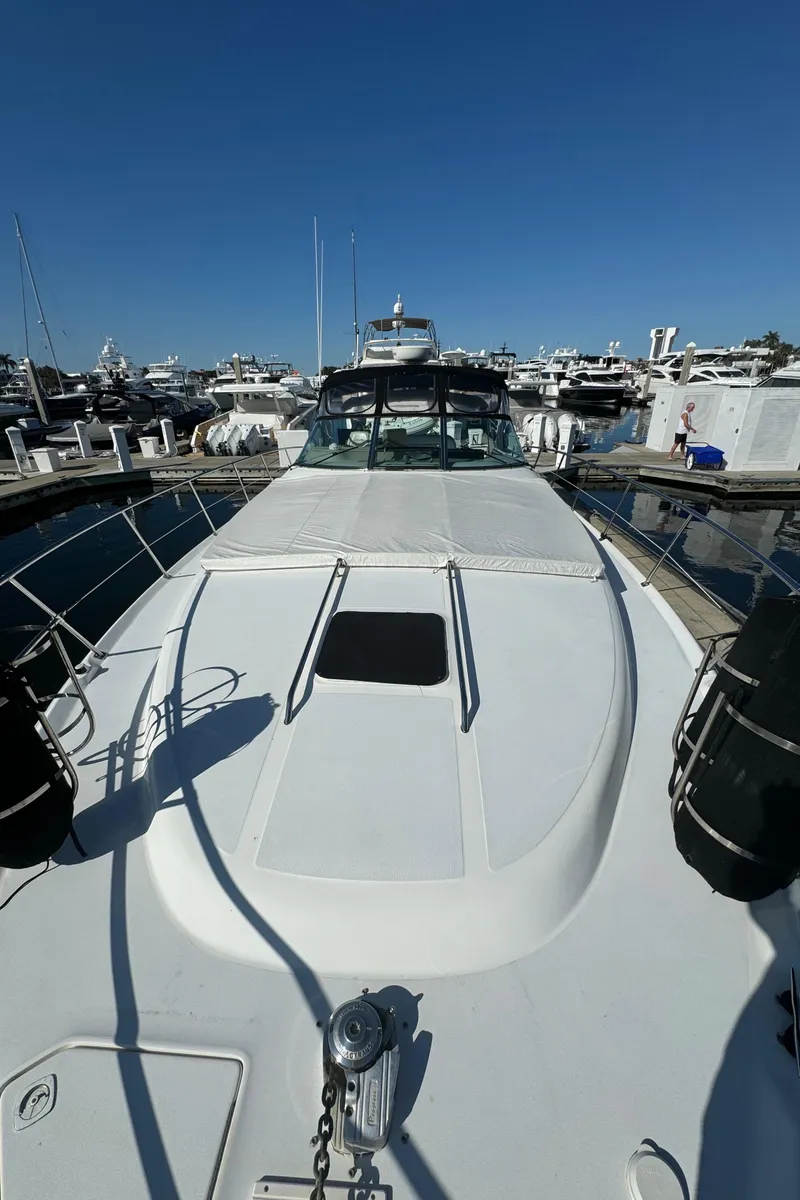 Slide: The Image of 1998 Sea Ray 400 Express Cruiser docked at marina under clear blue sky. - 10