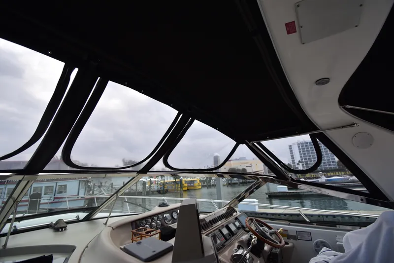 Slide: The Image of Interior view of 1998 Sea Ray 400 Express Cruiser cockpit with marina backdrop. - 12