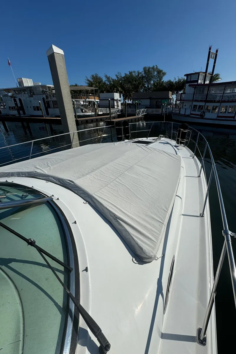 Slide: The Image of 1998 Sea Ray 400 Express Cruiser docked at marina under clear blue sky. - 13