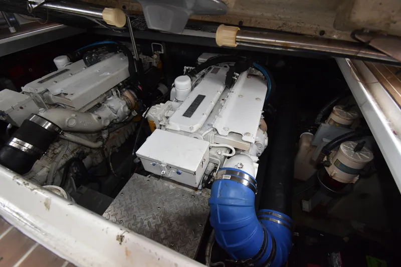 Slide: The Image of Engine room of 1998 Sea Ray 400 Express Cruiser with dual engines and blue hoses. - 17