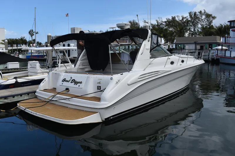 Slide: The Image of 1998 Sea Ray 400 Express Cruiser docked at marina, featuring sleek white design and black canopy. - 2