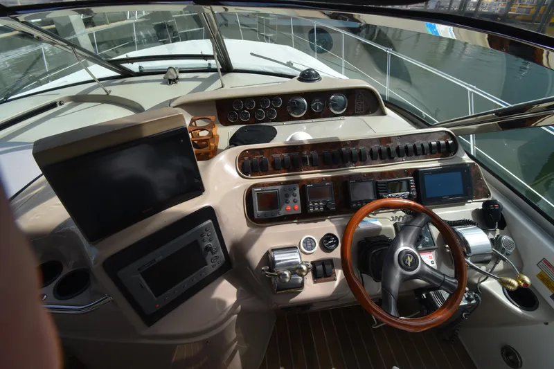 Slide: The Image of 1998 Sea Ray 400 Express Cruiser helm with advanced navigation controls and wooden steering wheel. - 3