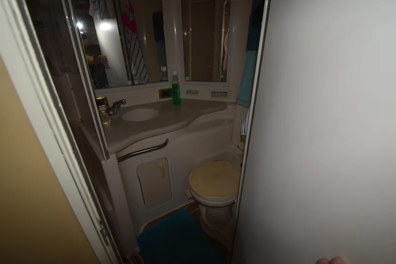 Slide: The Image of 1998 Sea Ray 400 Express Cruiser bathroom with sink, mirror, and toilet. - 9