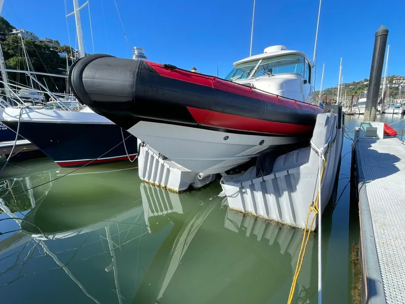 Slide: The Image of 2001 Protector Targa 28 boat docked in marina, featuring red and black detailing. - 0