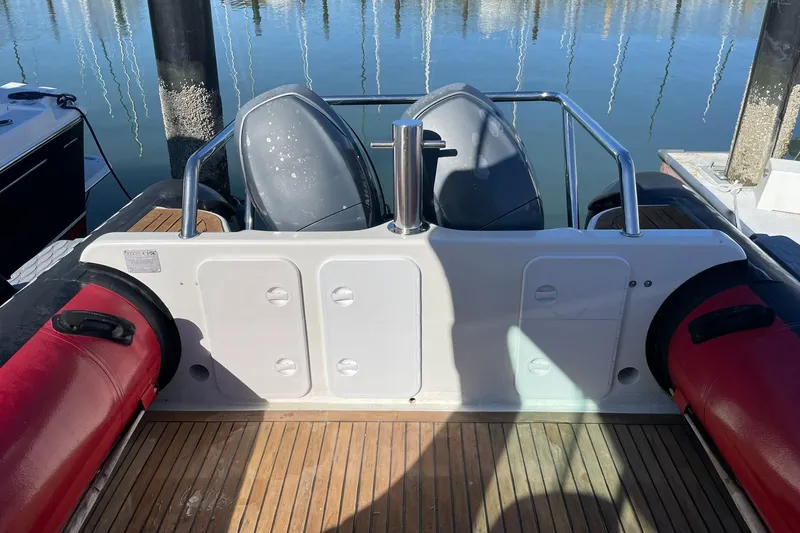 Slide: The Image of 2001 Protector Targa 28 boat with red inflatable sides and wooden deck at a marina. - 19