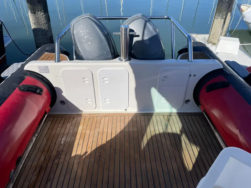 Slide: The Image of 2001 Protector Targa 28 boat interior with red and black seating, wooden deck, and storage compartments. - 20