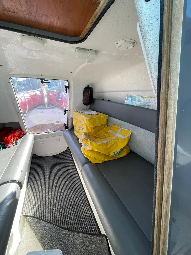 Slide: The Image of Interior of a 2001 Protector Targa 28 boat with seating and yellow life jackets. - 27