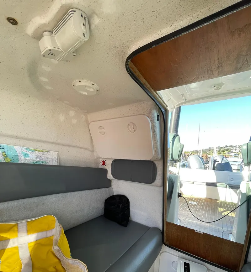 Slide: The Image of Interior of a 2001 Protector Targa 28 boat, featuring seating and a view of the deck. - 30