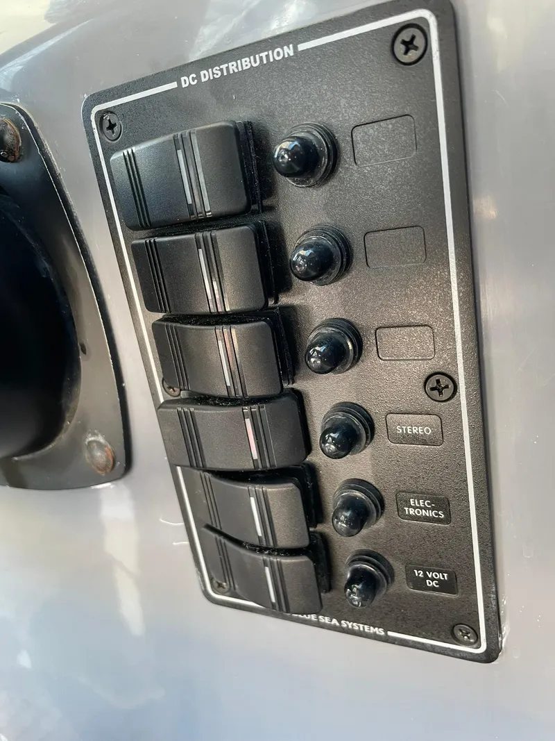 Slide: The Image of Control panel of a 2001 Protector Targa 28 boat, featuring DC distribution switches. - 32