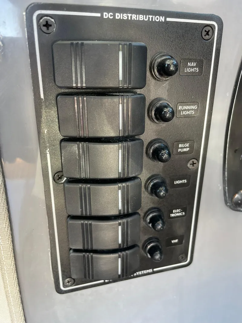 Slide: The Image of Control panel of a 2001 Protector Targa 28 boat with labeled switches. - 33