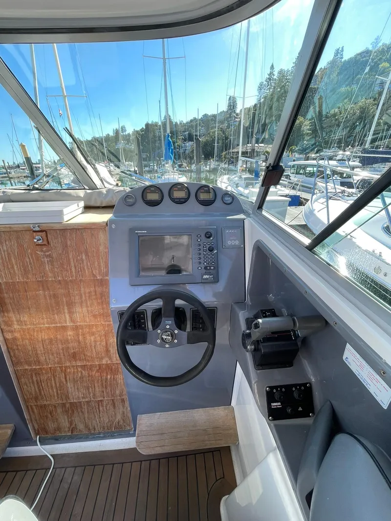 Slide: The Image of 2001 Protector Targa 28 boat cockpit with steering wheel and navigation controls. - 8