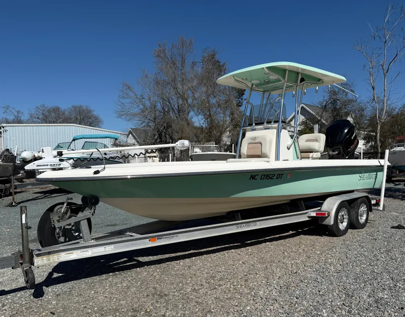 Slide: The Image of 2011 ShearWater 2200 boat on trailer, parked outdoors, clear sky background. - 3