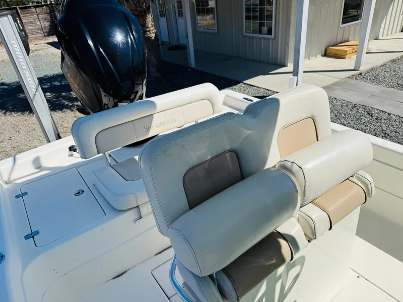 Slide: The Image of 2011 ShearWater 2200 boat interior with cushioned seating and outboard motor. - 6