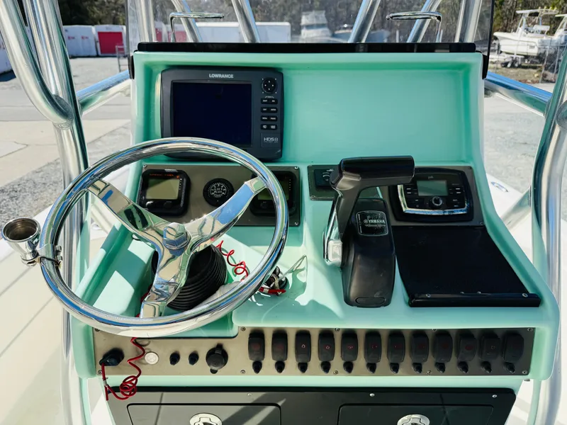 Slide: The Image of 2011 ShearWater 2200 boat console with steering wheel, navigation system, and controls. - 7