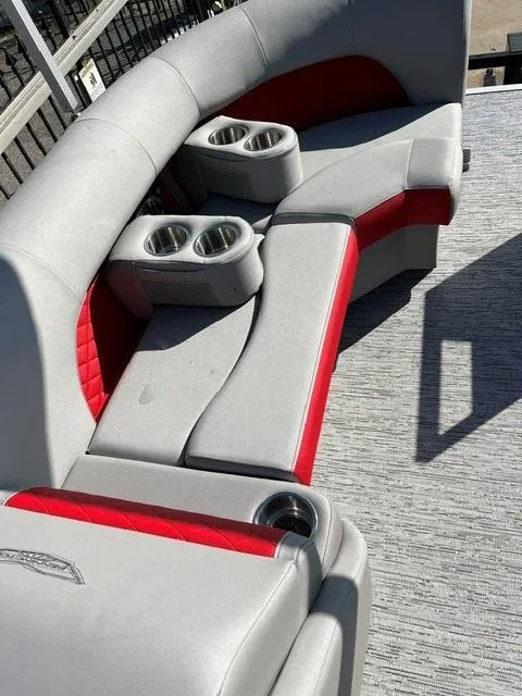 Slide: The Image of 2025 Bennington 21L Cruise boat seating with red accents and cup holders. - 11